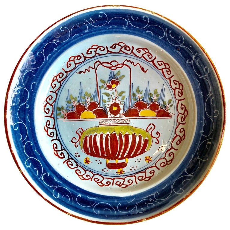 18th Century French Faience Charger: An 18th century French faience charger depicting a hanging basket of flowers. 13.5" dia.