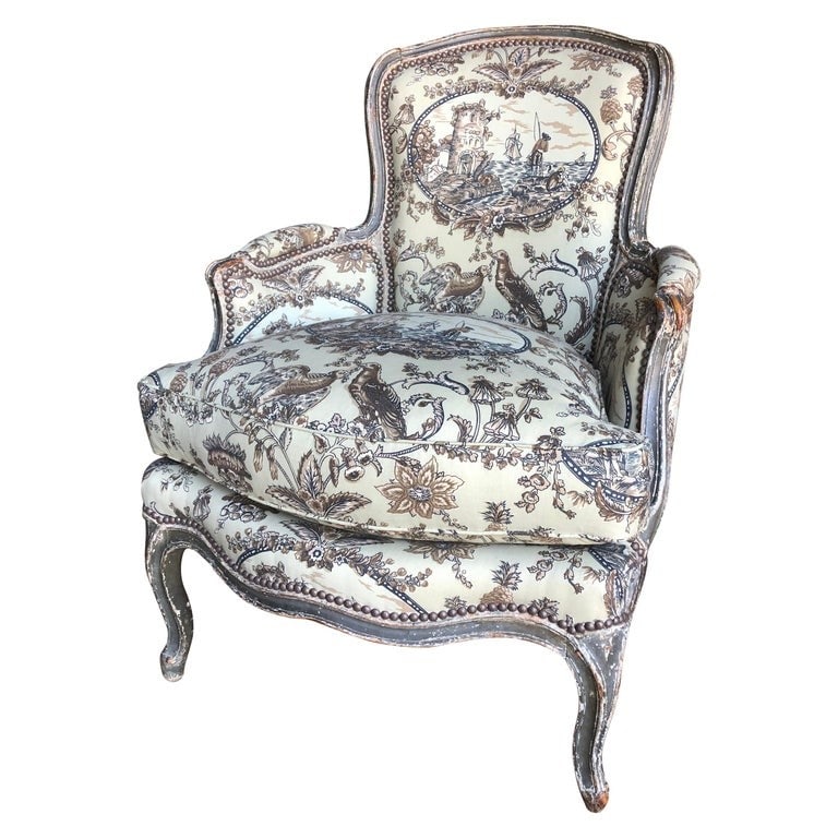 French Louis XV Period Bergere, Toile: A French Louis XV period bergere in original grey/green painted finish, newly upholstered in color coordinated toile de jouy fabric, circa 1760. 28" d x 29" w x 37" h