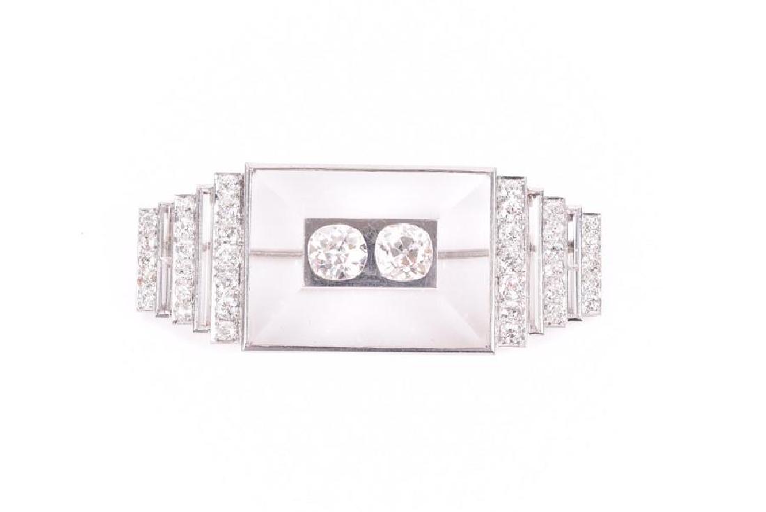 An Art Deco diamond plaque brooch possibly : An Art Deco diamond plaque brooch by Suzanne Belperron and Rene Boivinin the 'clou' design, the platinum mount set with a rectangular piece of rock crystal, inset to centre with two old cushion-cut di