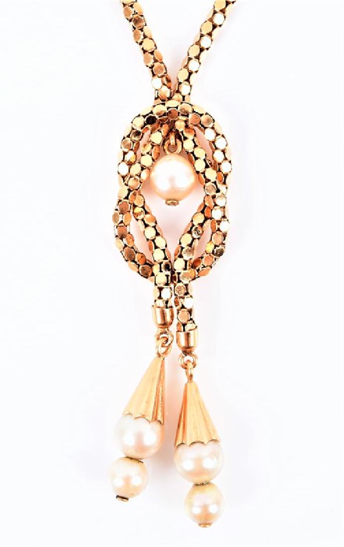 A yellow metal and pearl drop pendant necklace the: A yellow metal and pearl drop pendant necklace the fancy-link chain necklace with two tassel pendants set with two pearls each, beneath a stylised reef knot suspended with a pearl, the clasp stamped 7