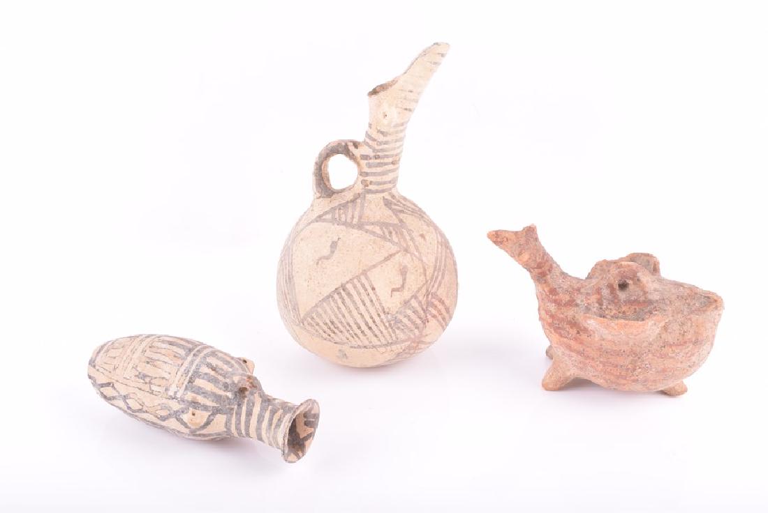 A collection of Cypriot hand modelled white painted: A collection of Cypriot hand modelled white painted ware, possibly Middle Bronze Age including an amphora bottle and flask, both decorated with geometric black on white design and a figural oil burner