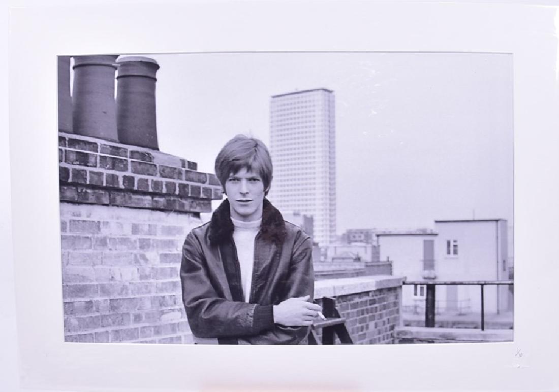 David Bowie: a mounted black and white photograph : David Bowie: a mounted black and white photograph taken on the roof of what is now Soho House, London in 1967, by Robin Bean, numbered to the mount 1/10, 35 cm x 55 cm. Provenance: Copyright own