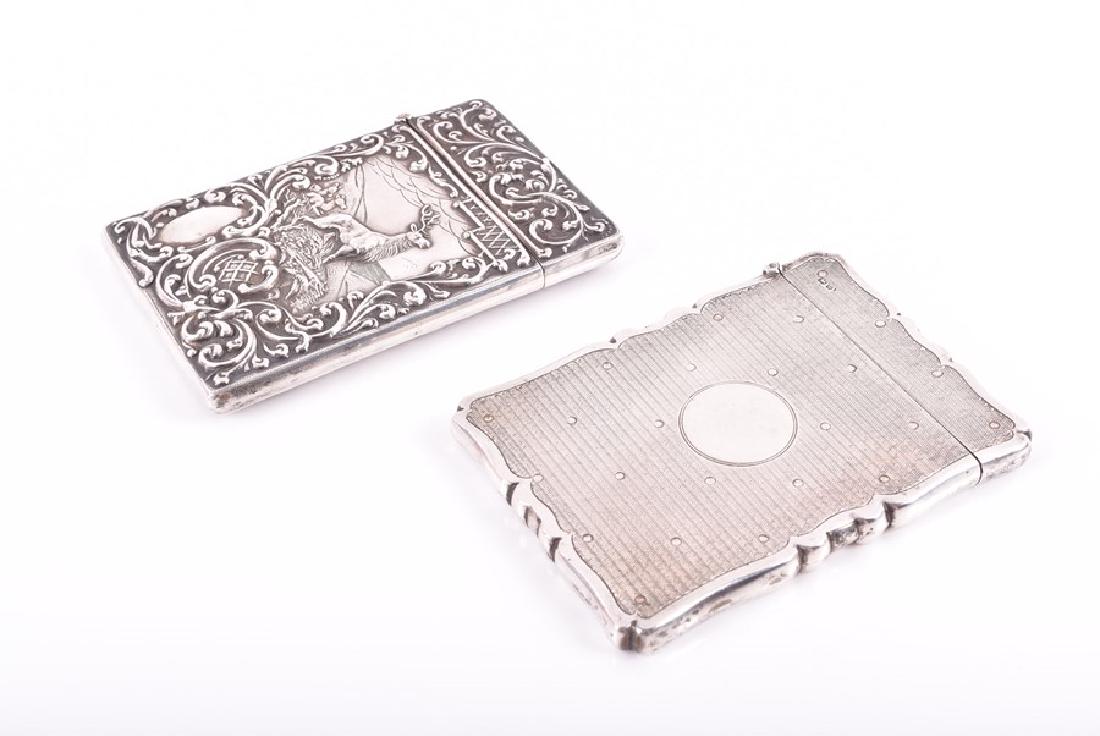 An Edwardian silver card case Birmingham 1901, by: An Edwardian silver card case Birmingham 1901, by Crisford & Norris Ltd, with detailed scroll embossed decoration, the front depicting a stag and deer on a hillside, 10 cm x 7 cm, together with anothe
