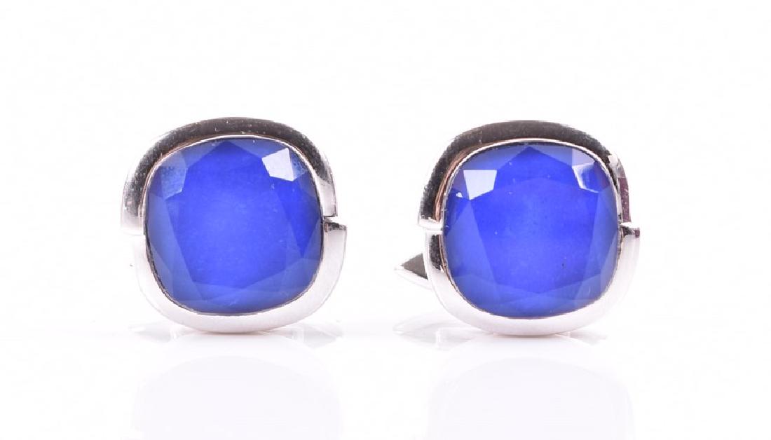 A pair of Stephen Webster 18ct white gold and: A pair of Stephen Webster 18ct white gold and chalcedony cufflinks of rounded form with segmented frames and faceted blue stones, in original fitted box. Note: this model was worn in a recent James Bo
