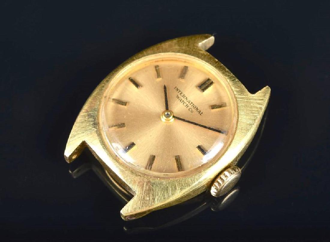 An IWC ladies 18ct yellow gold mechanical wristwatch: An IWC ladies 18ct yellow gold mechanical wristwatch the champagne dial with baton hour markers, in a shaped gold case, the movement signed, the case back signed International Watch Company and number