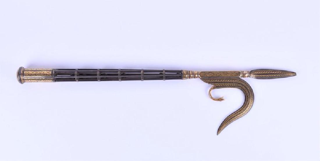 A 19th century metal elephant goad (ankus) possibly: A 19th century metal elephant goad (ankus) possibly Southern India, the open-work haft with six rattle bells, rounded basal cap, the whole with gilt damascened decoration, 57 cm long