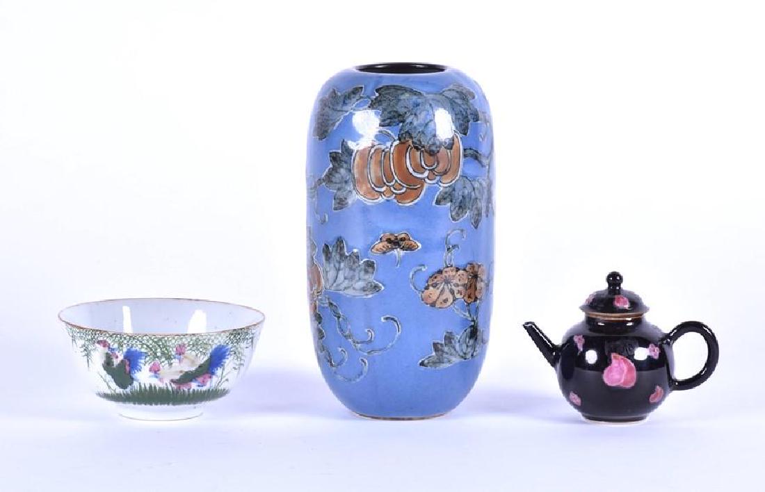 A 19th century or earlier Chinese porcelain bowl with: A 19th century or earlier Chinese porcelain bowl with polychrome painted roosters to one side of the body, raised on a short circular base, 12 cm diameter, together with a miniature Famille Noire teap