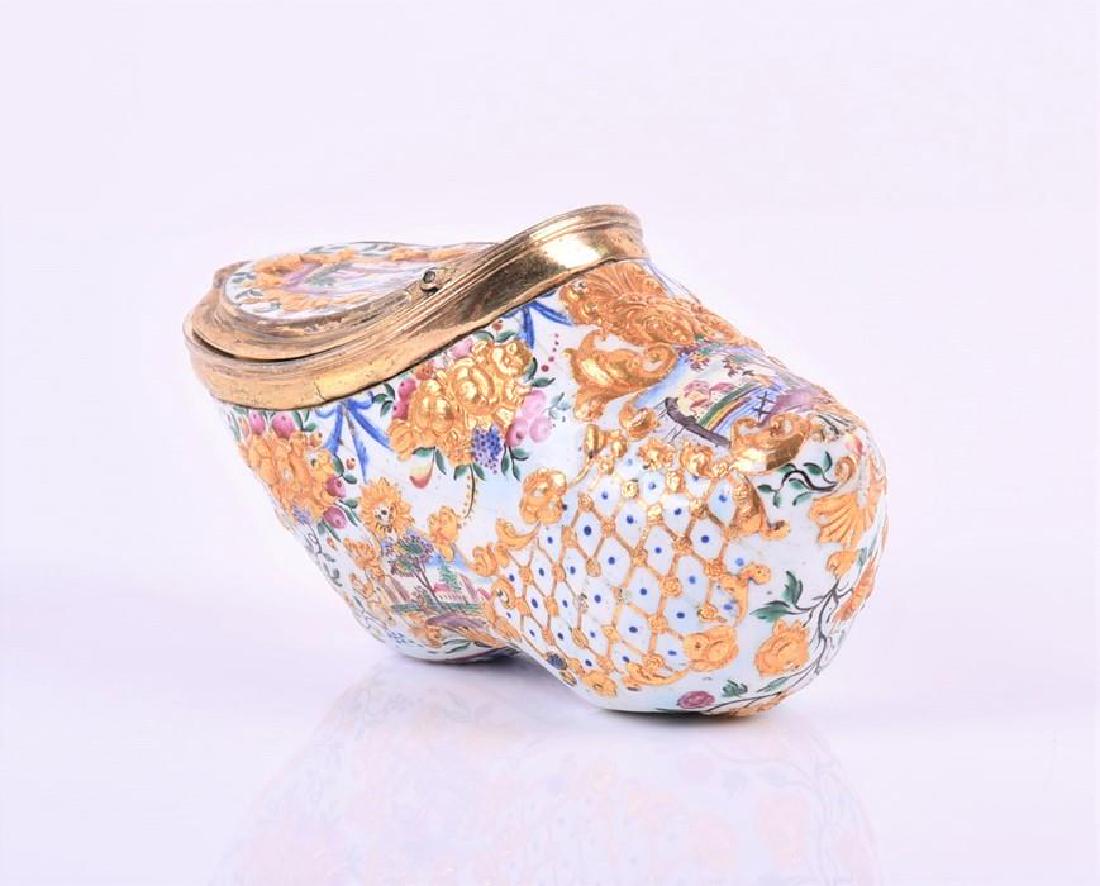 A Sabot-shaped German enamel snuff box circa 1740 with: A Sabot-shaped German enamel snuff box circa 1740 with gilt metal mounts and liner, painted with polychrome landscapes and swags within raised gilt scrolls, gilt female mask to front, 8.5 cm x 4.3 cm 