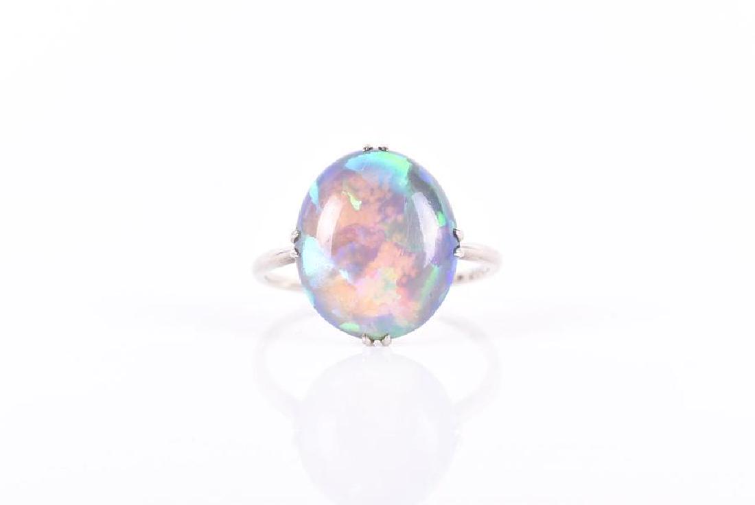 An 18ct white gold and opal ring set with an oval: An 18ct white gold and opal ring set with an oval cabochon opal within four double-claw setting, opal approximately 12 x 14 mm, size N, 2.6 grams.