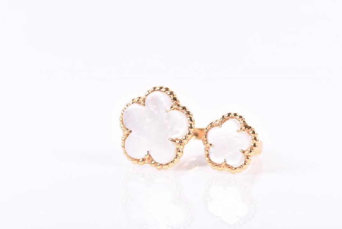 An 18ct yellow gold and mother-of-pearl floral ring in: An 18ct yellow gold and mother-of-pearl floral ring in the style of Van Cleef & Arpels, the split ring set with two terminals, with a larger and smaller mother-of-pearl five petal flower, size M 1/2, 