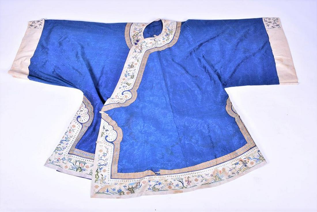A late 19th or early 20th century Chinese embroidered: A late 19th or early 20th century Chinese embroidered silk robe with detailed auspicious characters to front and back, on a blue ground, and embroidered panels depicting various scenes in coloured sil