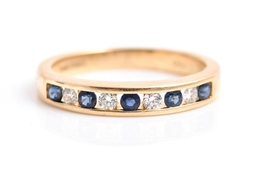 A diamond and sapphire ring the yellow metal mount: A diamond and sapphire ring the yellow metal mount channel-set with alternating round-cut stones, the shank stamped 750, size K, 3 grams.