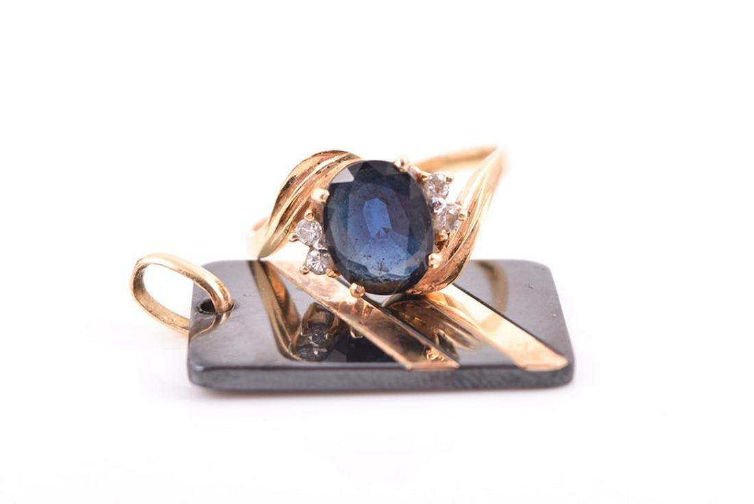 An 18ct yellow gold and sapphire ring set with a mixed: An 18ct yellow gold and sapphire ring set with a mixed oval-cut sapphire in a crossover-style mount, with diamond accents to shoulders, size P, 4.42 grams, together with a yellow metal and hematite pe