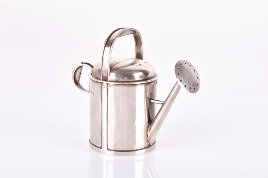 A Victorian novelty silver condiment in the form of a: A Victorian novelty silver condiment in the form of a watering can the top depressing to leave opening for pepper, hallmarked London 1887, makers mark Thomas Johnson II, retailed by Percy Edwards & Co