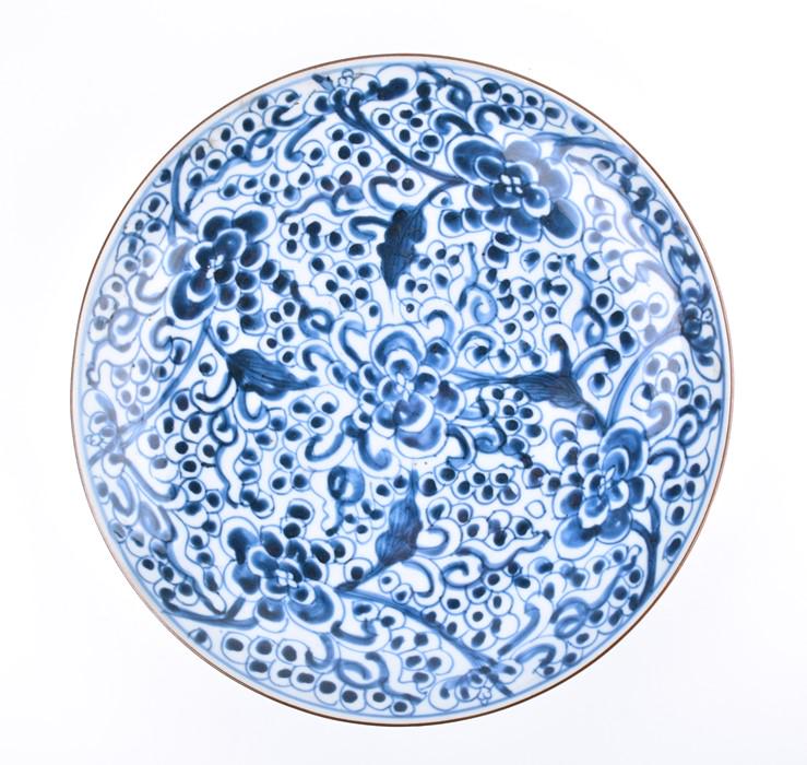 An 18th century Chinese blue and white porcelain plate: An 18th century Chinese blue and white porcelain plate probably late Kangxi, with floral pattern throughout, 28 cm diameter.