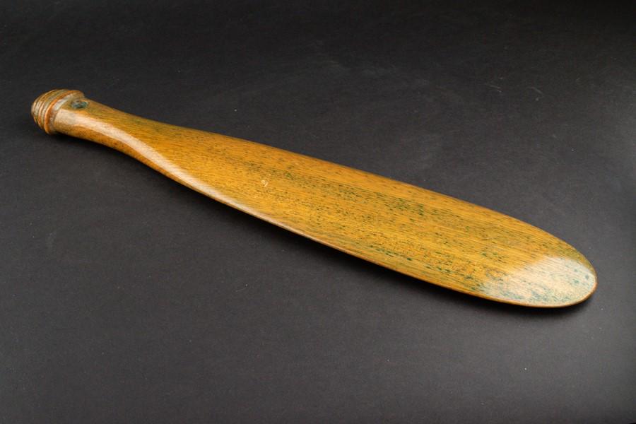 A 19th century stained wood Maori Patu Paroa with: A 19th century stained wood Maori Patu Paroa with smooth varnished wood surfaces on either side and turned finial to the handle, 39 cm long.