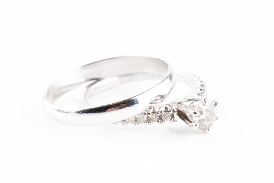 A diamond engagement ring set with a round: A diamond engagement ring set with a round brilliant-cut diamond of approximately 0.33 carats, approximate clarity I3, with diamonds set to the shoulders, the shank marked 585, size N 1/2, together wi