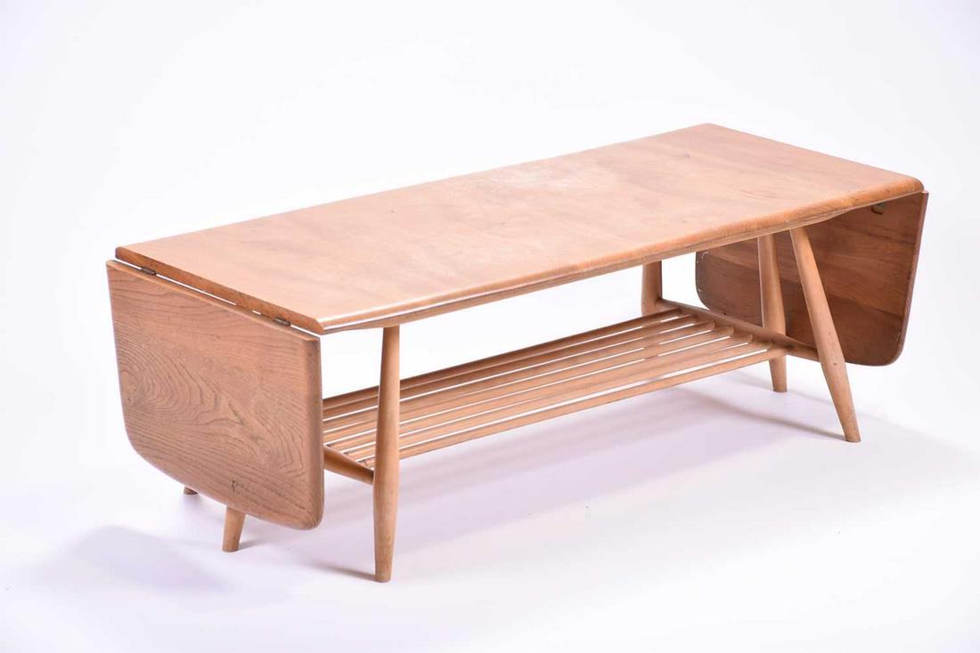 An Ercol extendable coffee table, with a pair of drop: An Ercol extendable coffee table, with a pair of drop flaps and rack below. 108 cm wide, 46 cm deep, 37 cm high.