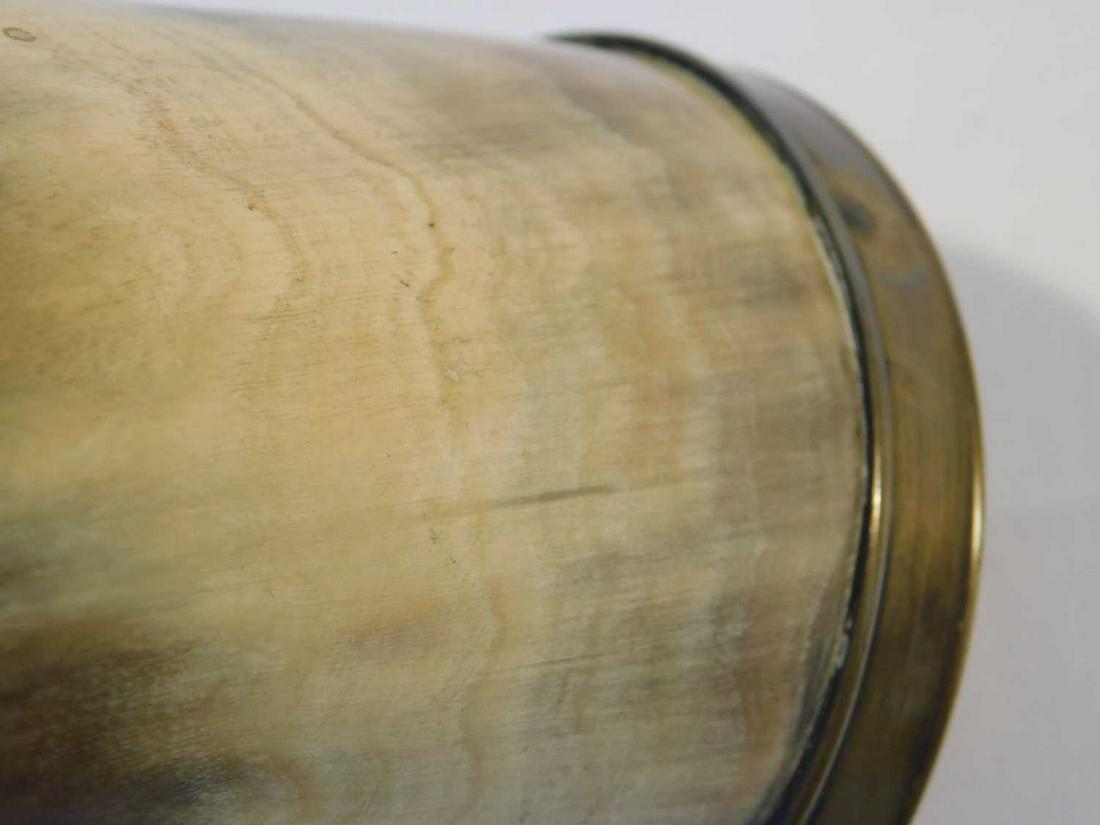 A 19th century brass mounted cow horn powder flask, the: A 19th century brass mounted cow horn powder flask, the nozzle with ring turned decoration and suspension ring, the end cap with milled rim, ring turning and central suspension ring. (Dimensions: 27cm