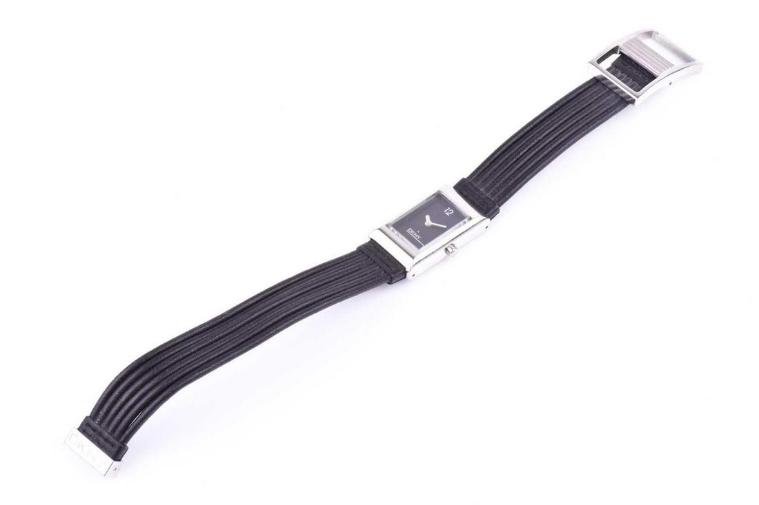 A ladies DKNY stainless steel wristwatch, with: A ladies DKNY stainless steel wristwatch, with rectangular black dial, numbered 12 to top of dial, and 'DKNY' to lower half, on original black leather strap.