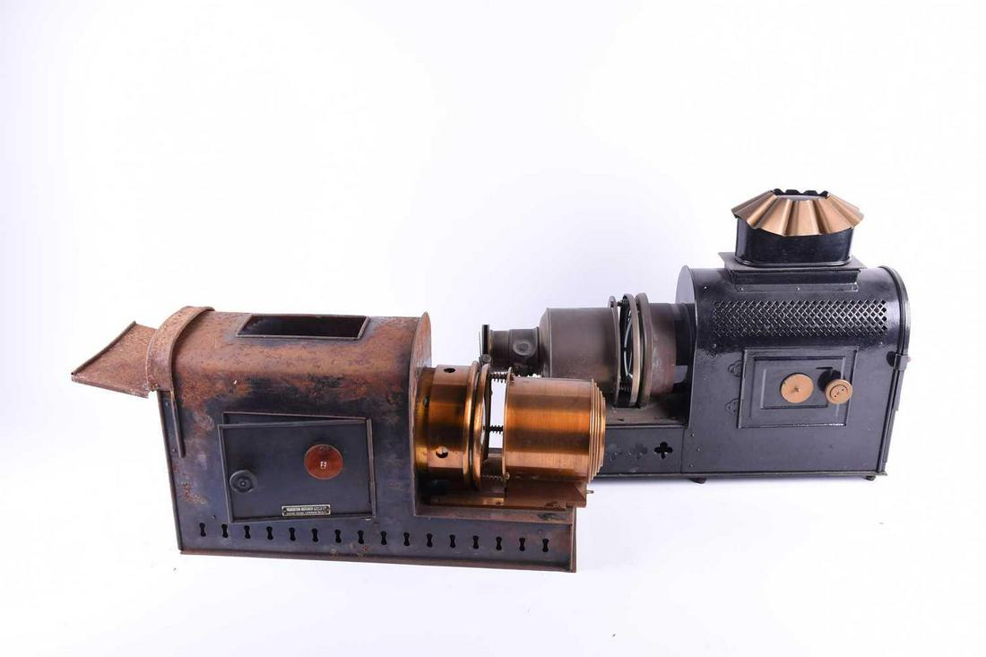 A Houghton-Butcher Magic Lantern, in fitted carry case,: A Houghton-Butcher Magic Lantern, in fitted carry case, together with a further, loose Magic Lantern (a/f). (Qty: 2) Qty: (2) Footnote: No slides present, both with signs of wear and rust in places.