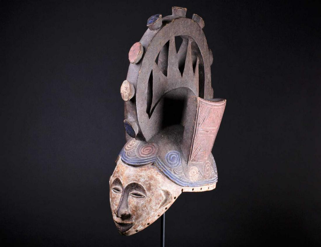 An Igbo Maiden Spirit mask, Nigeria, in red, blue and: An Igbo Maiden Spirit mask, Nigeria, in red, blue and white pigment, the edges pierced with holes, 45cm Footnote: The late Reverend Alan Dupuy