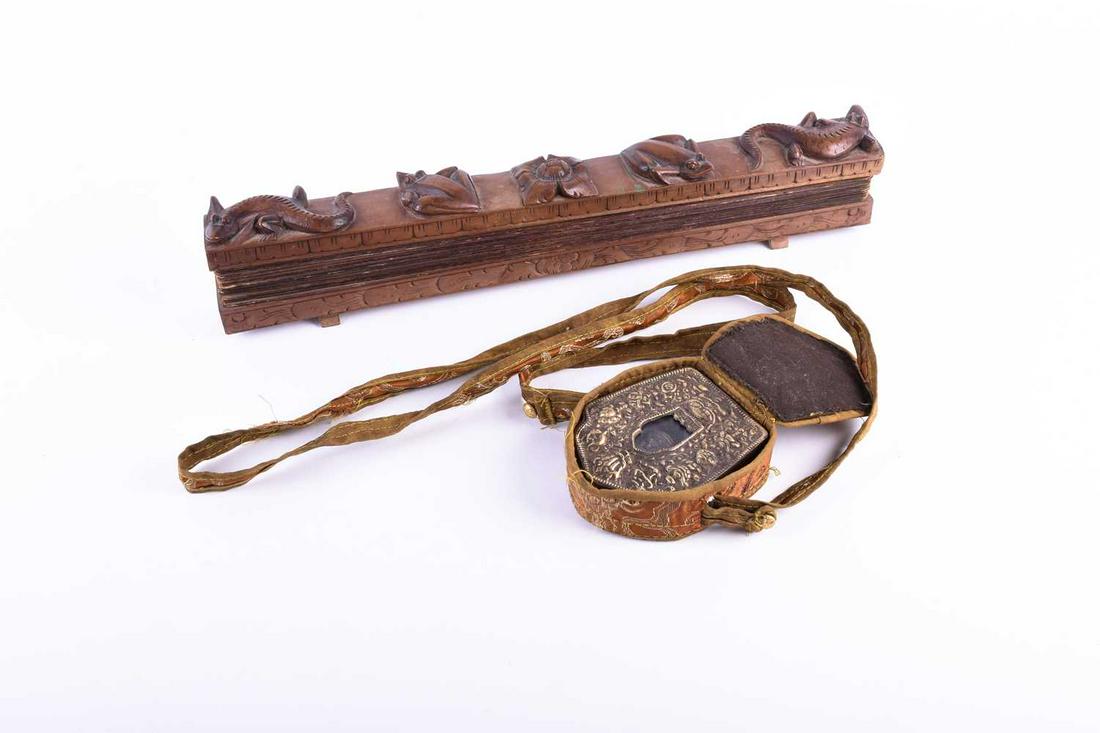 A Tibetan traveling Buddhist shrine, Gau, copper cased: A Tibetan traveling Buddhist shrine, Gau, copper cased with a white metal embossed front with auspicious symbols framing a shaped niche with glass panel enclosing a seated figure of Buddha, in cloth c