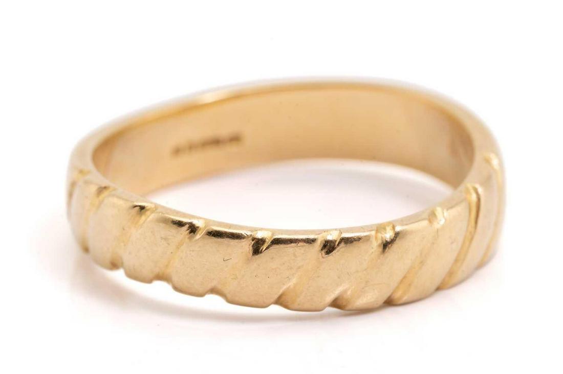 Andrew Grima - a wedding band in 18ct yellow gold, the curved band centred with a diagonal ribbed: Andrew Grima - a wedding band in 18ct yellow gold, the curved band centred with a diagonal ribbed detail, signed 'GRIMA', London hallmarked '750' with maker's mark 'AGLtd', 1978, size Q, total weight