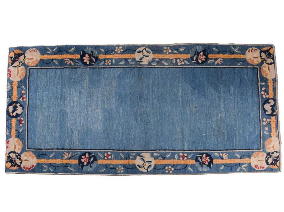 A Chinese Peking blue ground rug, late Qing, within borders of bamboo and butterflies, bearing a (1 of 6)