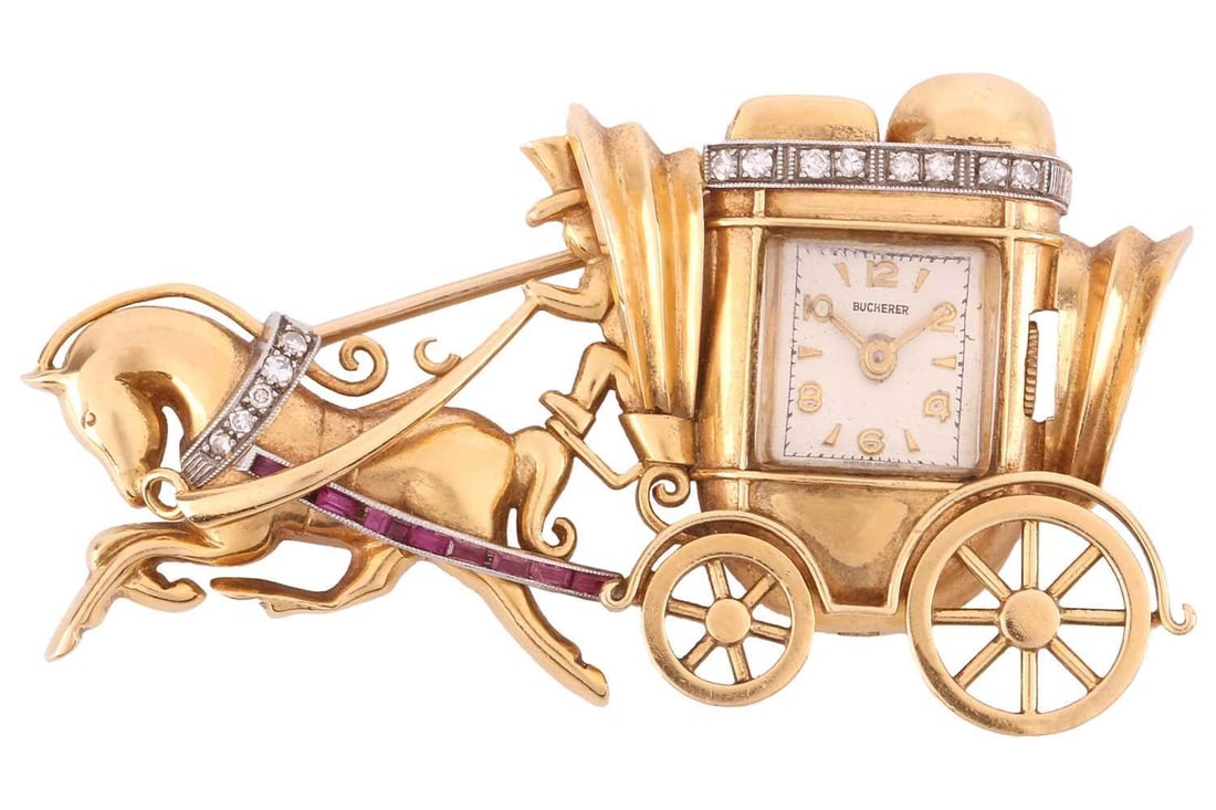 A Bucherer diamond and ruby set horse and carriage brooch watch, featuring a Swiss-made hand-wound: A Bucherer diamond and ruby set horse and carriage brooch watch, featuring a Swiss-made hand-wound movement in an 18ct gold stylised carriage mount with calibrated rubies and 8-cut diamonds set into t