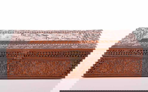 A large finely carved Persian rectangular sandalwood table box, Qajar Dynasty, 19th century, the: A large finely carved Persian rectangular sandalwood table box, Qajar Dynasty, 19th century, the cover carved with a royal hunting party within a meandering floral border, 34 cm long x 20 cm wide x 8.