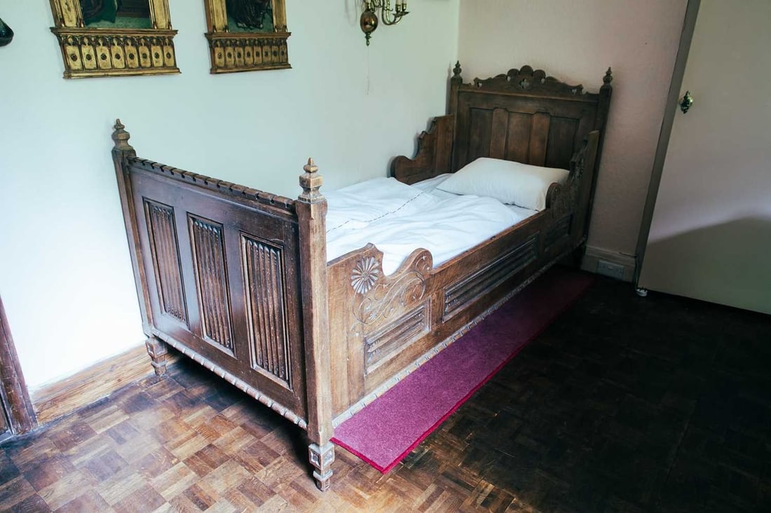 A French 19th-century "Gothic" carved brown oak single bed (extended) with castellated ends and: A French 19th-century "Gothic" carved brown oak single bed (extended) with castellated ends and linen fold panels. 216 cm x 96 cm internal size