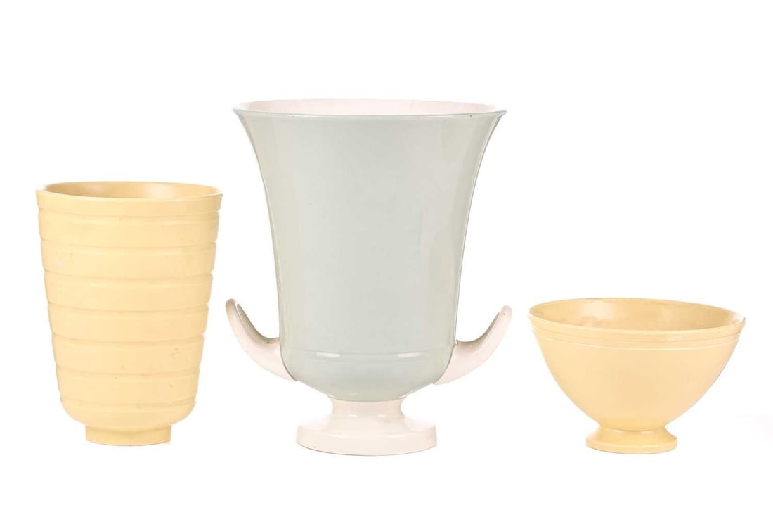 Keith Murray for Wedgwood, a large celadon-green glazed table vase, with twin handles on a circular: Keith Murray for Wedgwood, a large celadon-green glazed table vase, with twin handles on a circular foot, 26 cm high, together with a yellow-glazed footed vase, of ribbed design, 19 cm high and a simi