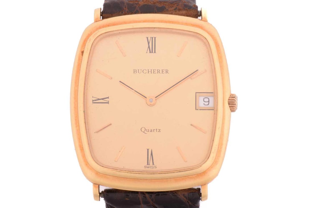 A Bucherer 18ct Gold Gentleman's Dress Watch Model: 2219 Serial: 955 006 Case Material: 18ct Gold: A Bucherer 18ct Gold Gentleman's Dress Watch Model: 2219 Serial: 955 006 Case Material: 18ct Gold Case Diameter: 30mm Dial: Gold Numerals: Roman Movement: Quartz Functions: Date Strap: Brown Leather B