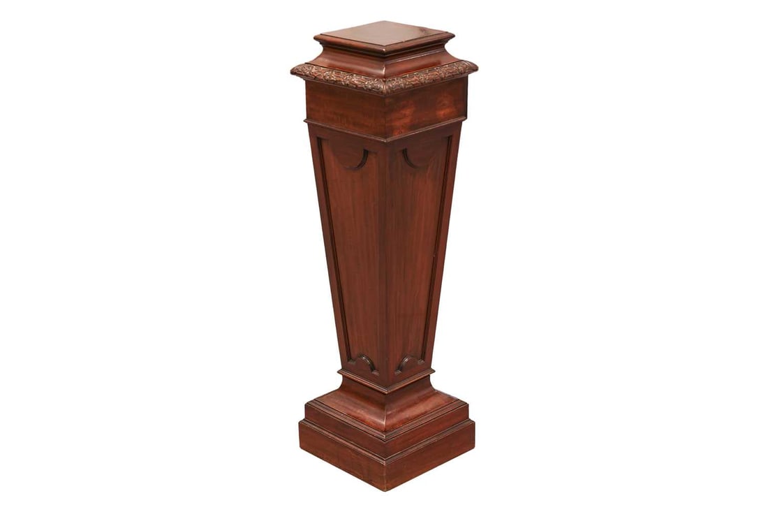 An Edwardian mahogany square section pedestal of Neo-Classical form with decorative carved and mould: An Edwardian mahogany square section pedestal of Neo-Classical form with decorative carved and moulded decoration, 31 cm x 31 cm x 108 cm overall height Some scratches and chips to decoration commensu
