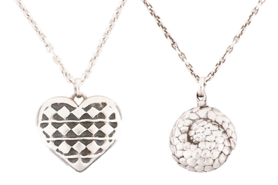 Two long necklaces, by Patrick Mavros. To include a textured heart locked on a long chain, and a Pan: Two long necklaces, by Patrick Mavros. To include a textured heart locked on a long chain, and a Pangolin pendant on a long chain. With Patrick Mavros box