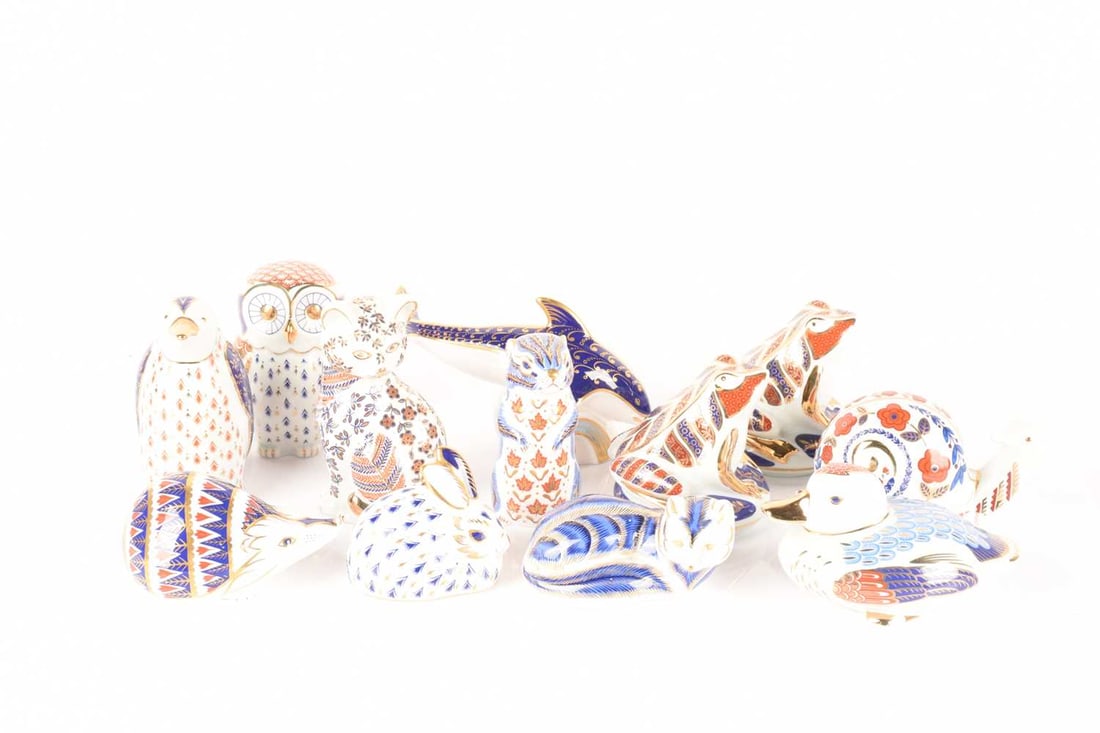 A collection of Royal Crown Derby paperweights comprising an Imari pattern Dolphin and a Fox, both w: A collection of Royal Crown Derby paperweights comprising an Imari pattern Dolphin and a Fox, both with gold stoppers, a Chipmunk, a Rabbit, and a Hedgehog with silver stoppers, and a Penguin, Snail, 