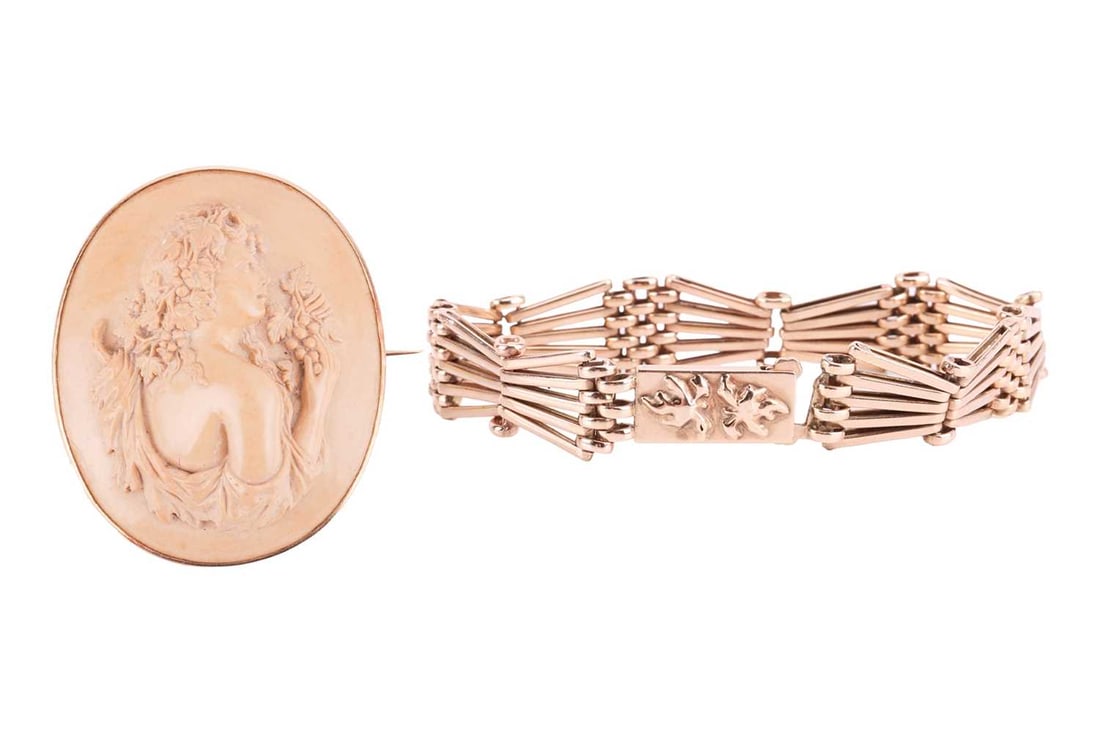 A Victorian lava cameo brooch and a gate link bracelet; the lava cameo featuring a young lady with v: A Victorian lava cameo brooch and a gate link bracelet; the lava cameo featuring a young lady with vines in high relief, measuring 53 x 44mm, mounted in yellow metal, with brooch pin fitting; the gate