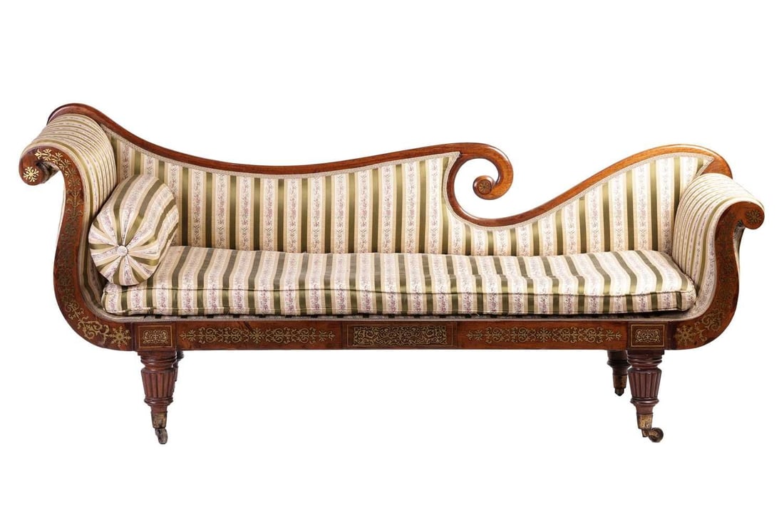 In the manner of John McLean a Regency brass inlaid rosewood double scroll chaise longue, with spent: In the manner of John McLean a Regency brass inlaid rosewood double scroll chaise longue, with spent back rail, striped sateen upholstery and horsehair squab and bolster en suite, supported by four sh