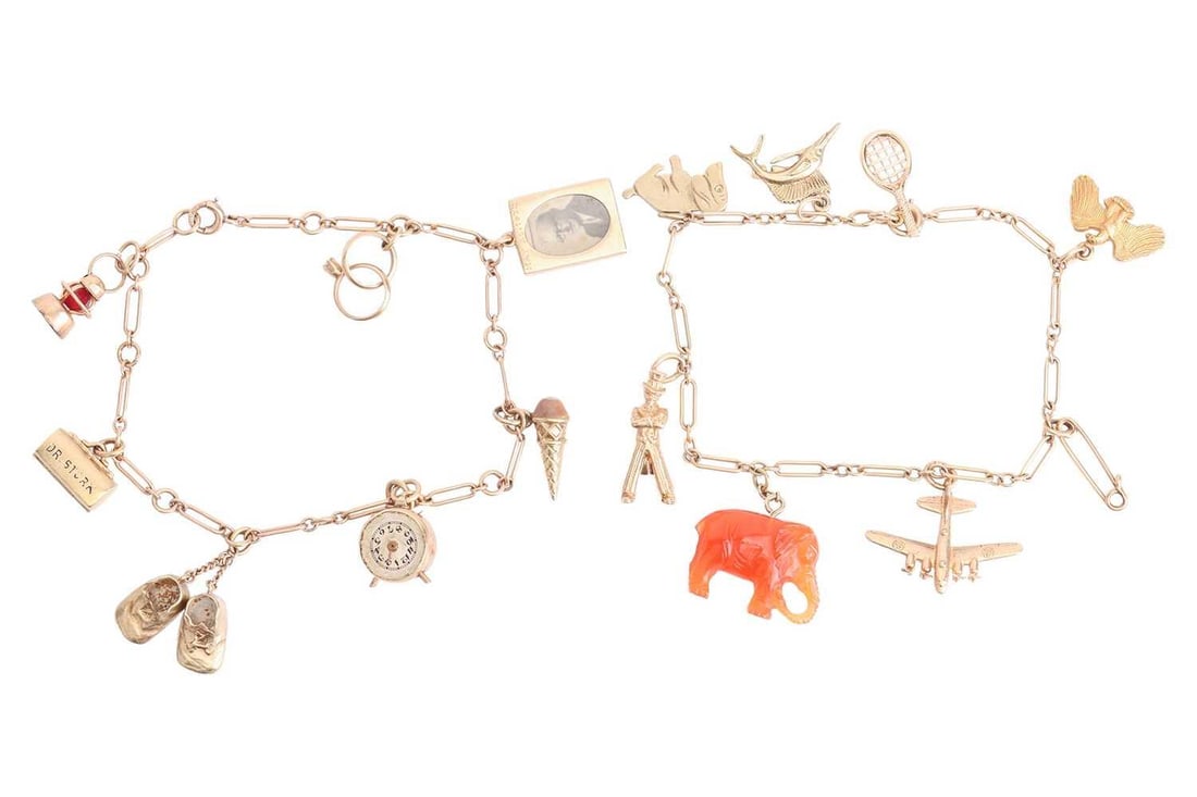 Two charm bracelets with a variety of charms; the first including a miniature photo frame containing: Two charm bracelets with a variety of charms; the first including a miniature photo frame containing photos of Henry and Idabelle Firestone, a 'Dr Stork' doctor's bag opening to reveal an enamel baby,