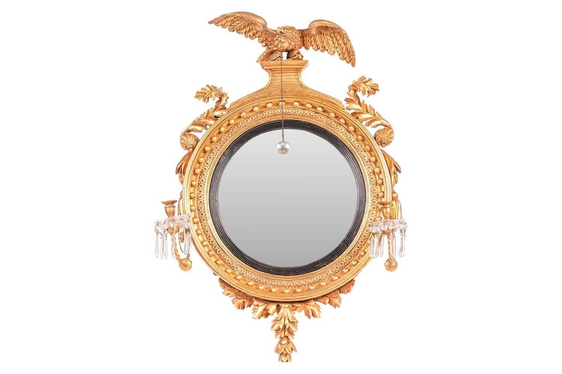 An early 19th-century carved wood and gilt gesso circular convex wall mirror, with a spread eagle (1 of 2)