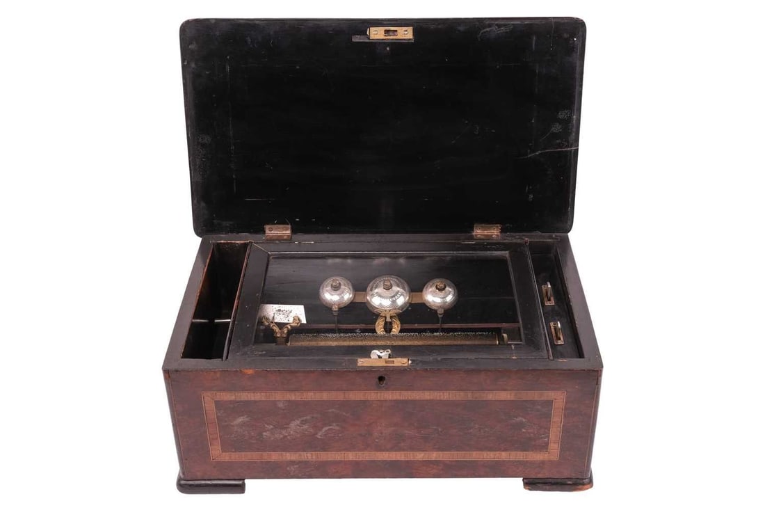 A crank wound Swiss (Bells insight) cylinder music box, late 19th century, probably playing 8 airs,: A crank wound Swiss (Bells insight) cylinder music box, late 19th century, probably playing 8 airs, (air sheet) missing) on three bells with a distinctive gilt dove hammer, in an amboyna and tulipwood