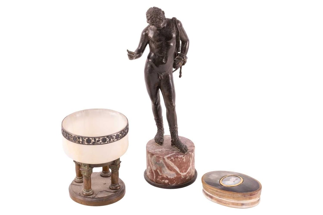A onyx and bronze miniature font, with floral rim, four turned supports and cylindrical base, 10 cm: A onyx and bronze miniature font, with floral rim, four turned supports and cylindrical base, 10 cm diameter, 12 cm high; a bronzed metal figure of Roman nude on a red marble cylindrical base, 28.5 cm