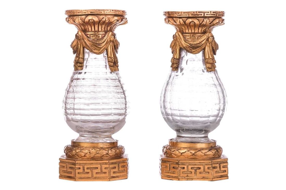 A pair of Regency rock crystal cut glass and ormolu vases, ribbon swag decoration over octagonal: A pair of Regency rock crystal cut glass and ormolu vases, ribbon swag decoration over octagonal bases with Greek key motifs, 16.5 cm high. Qty: (2)