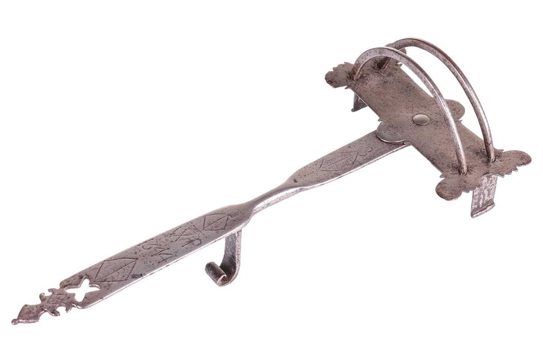 A scarce dated 17th-century iron toasting trivet stand, with a swivel head, the handle with the: A scarce dated 17th-century iron toasting trivet stand, with a swivel head, the handle with the chiselled date 1644 and overlapping V''s and the letter "P" and diamond device, with shaped and pierced