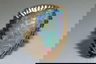 A large opal cocktail ring, the gadrooned triangular head collet-set with a free-formed polished