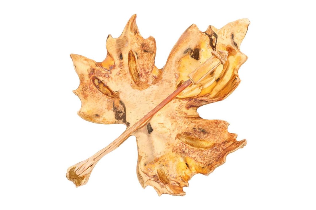 Garrard & Co. - a leaf brooch in 18ct gold, realistically modelled as a maple leaf, brooch fittings: Garrard & Co. - a leaf brooch in 18ct gold, realistically modelled as a maple leaf, brooch fittings to verso, stamped sponsor's mark for Garrard and London import marks 1977, measuring 4.8 x 3.7 cm, i