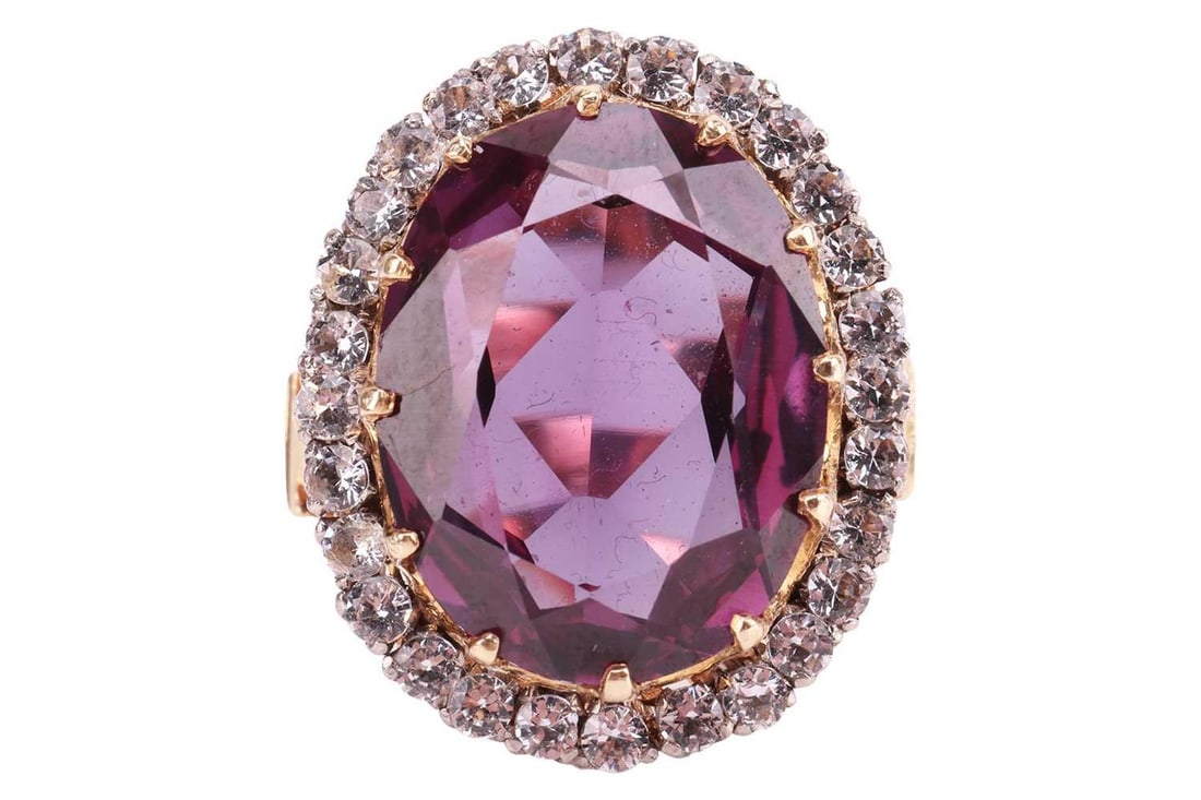 A gem-set dress ring, featuring a synthetic colour-change sapphire, measuring approximately 18mm x: A gem-set dress ring, featuring a synthetic colour-change sapphire, measuring approximately 18mm x 14mm, in a twelve-claw setting, surrounded by round-cut colourless synthetic spinel, in a bi-colour m