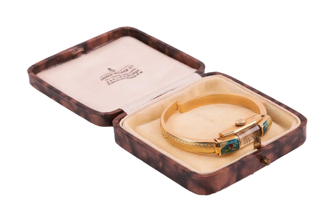 Bucherer - an enamel cocktail watch, featuring a manual wind movement, a silver-tone dial with: Bucherer - an enamel cocktail watch, featuring a manual wind movement, a silver-tone dial with gold-tone baton hour markers under a shaped crystal, the 10.5 mm wide case and sprung bracelets embellish