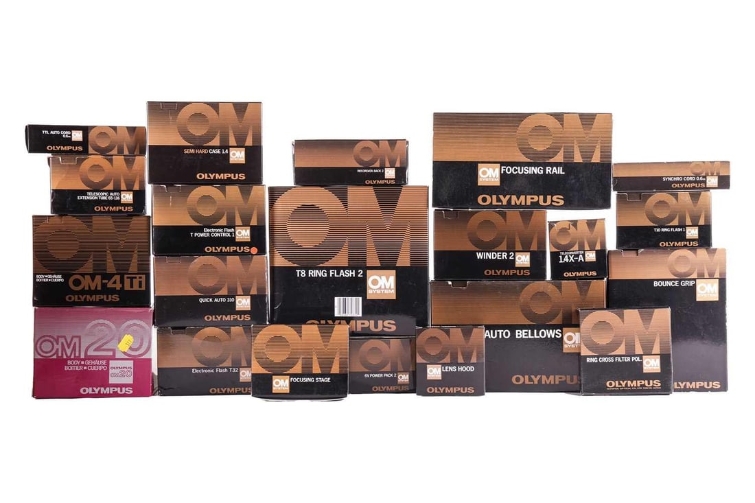 A large collection of boxed Olympus OM System cameras and accessories, comprising: an OM-4 Ti camera: A large collection of boxed Olympus OM System cameras and accessories, comprising: an OM-4 Ti camera body, an OM20 body, a T8 Ring Flash 2, a Winder 2, a Bounce Grip, Auto Bellows, Semi Hard Case 1.4,